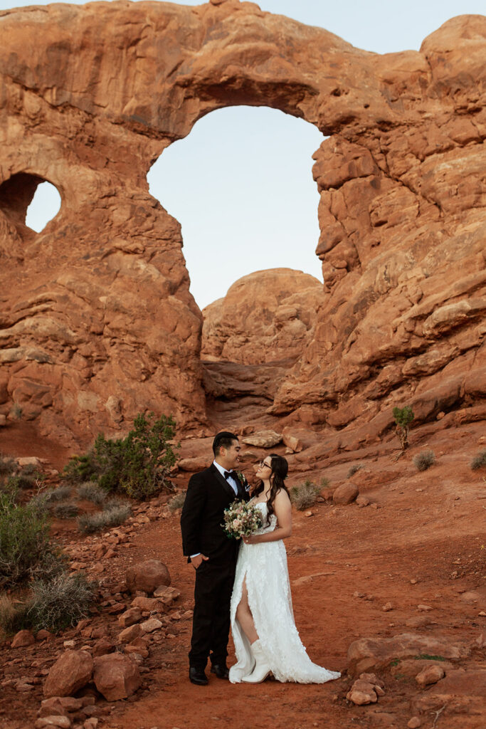 couple stands under arches at Moab elopement