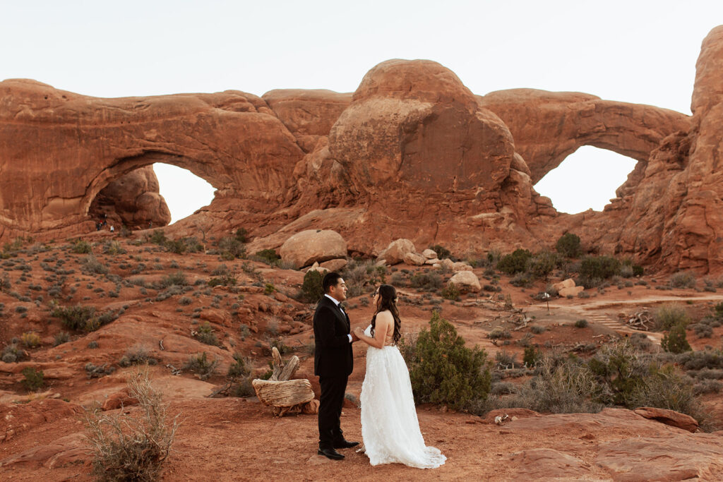 couple holds hands at Arches National Park Moab