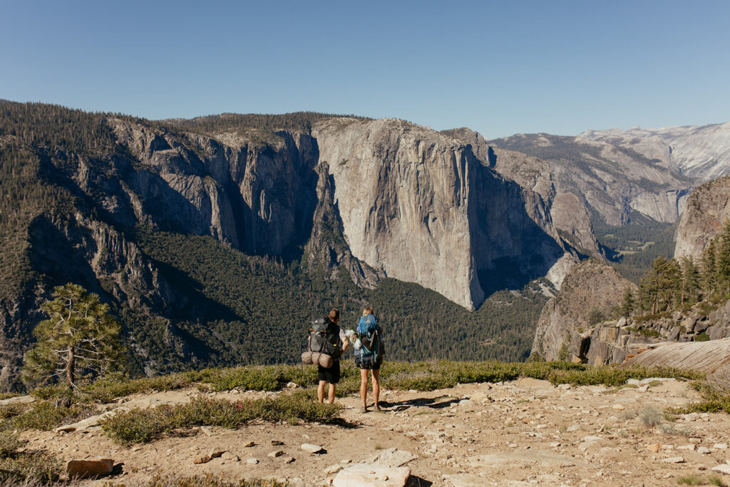 couple looks over Yosemite Valley wearing Yosemite backpacking gear