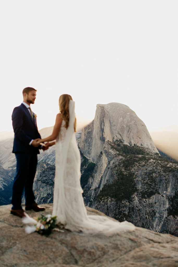couple holds hands at Glacier Point Yosemite elopement