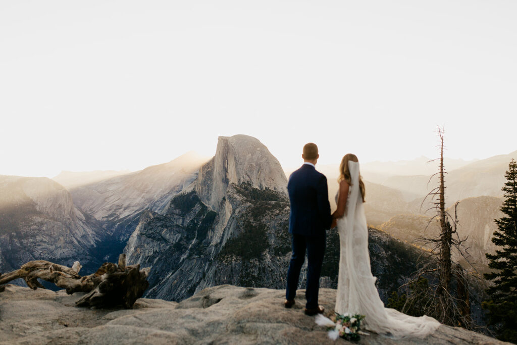 couple looks at Half Dome during sunrise elopement