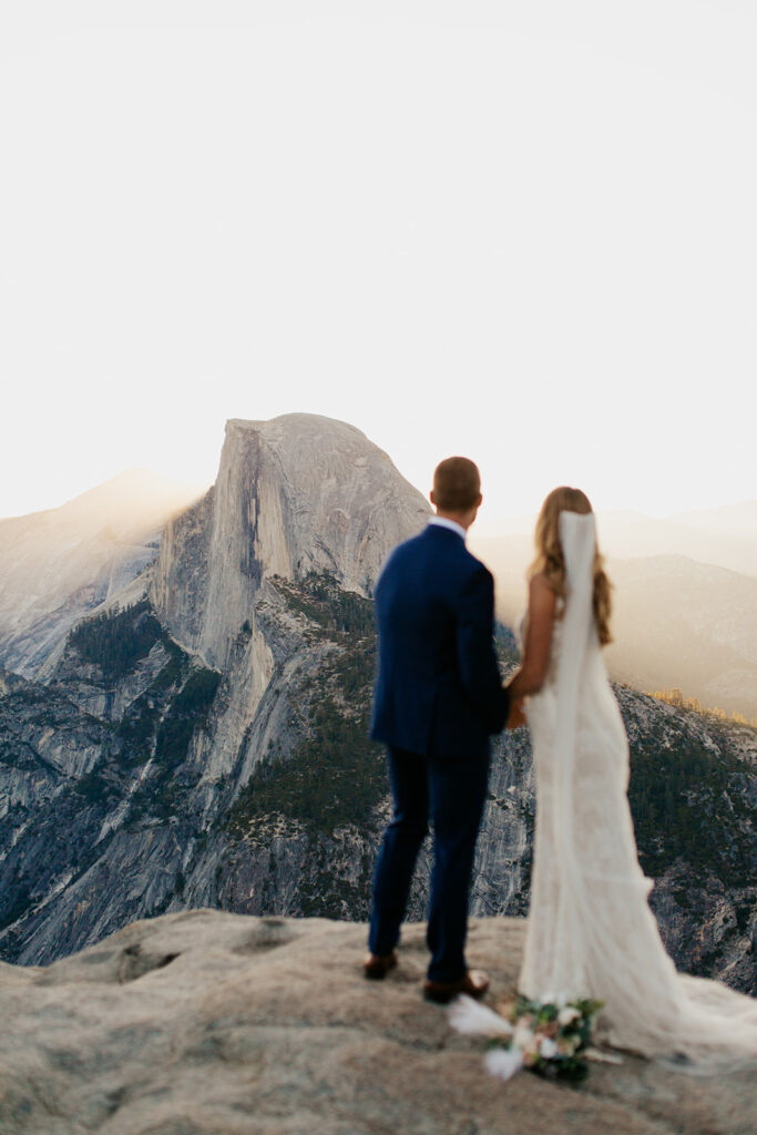 couple looks at Half Dome at sunrise elopement