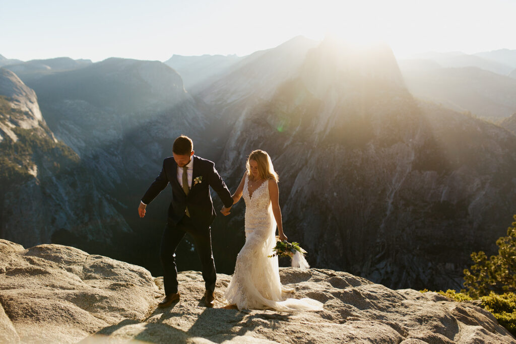 couple walks away from Half Dome during sunrise elopement