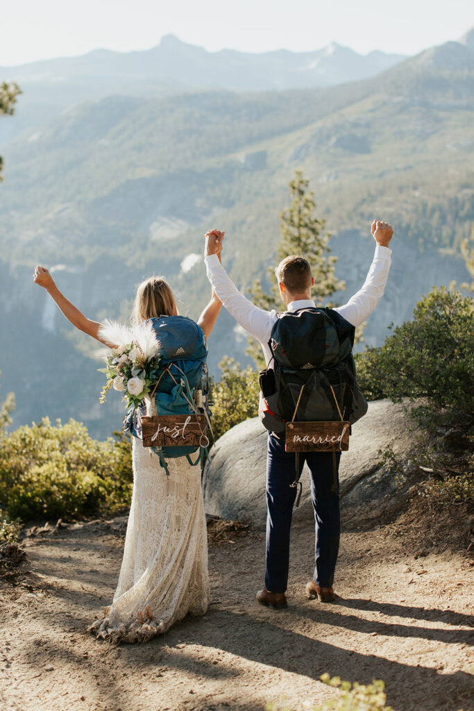 couple holds hands in the air at Yosemite backpacking elopement
