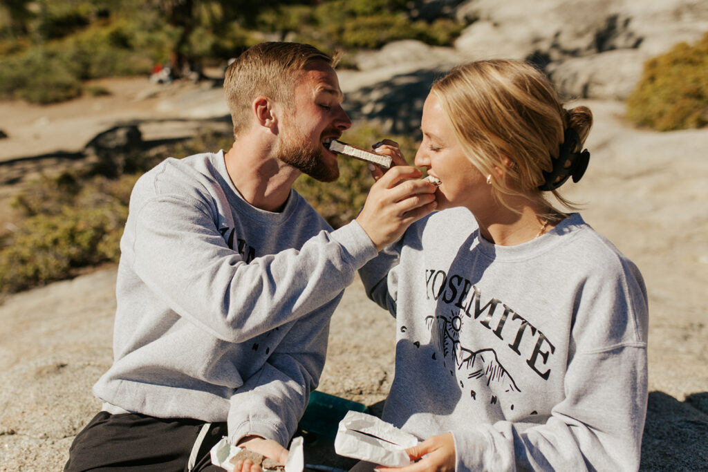 couple eats ice cream sandwich at Glacier Point sunrise elopement