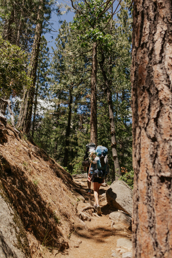 couple hikes through woods at Yosemite elopement
