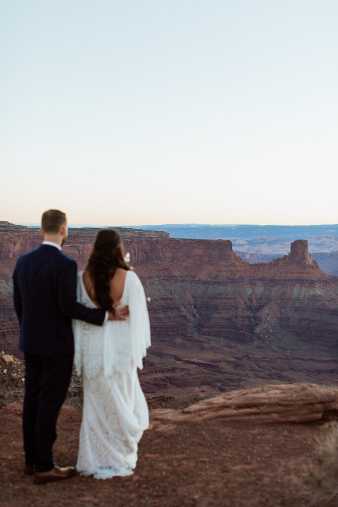 couple looks at canyon at Dead Horse Point State Park sunrise elopement