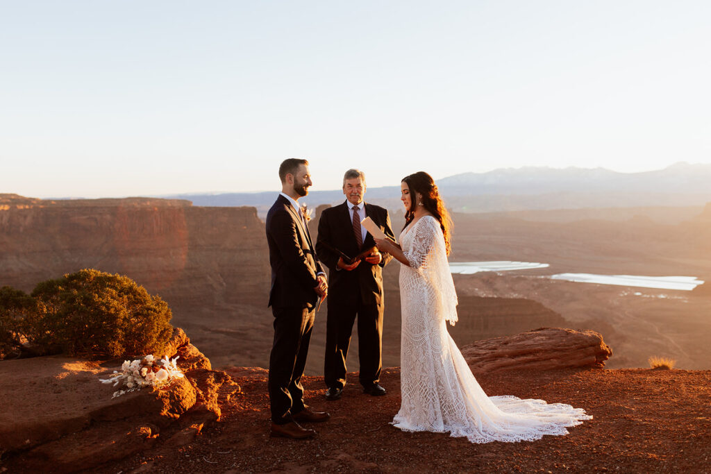 couple exchanges vows at sunrise Moab adventure elopement