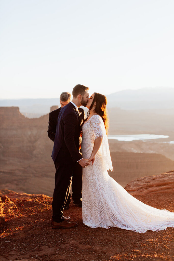 couple kisses during wedding ceremony at Moab adventure