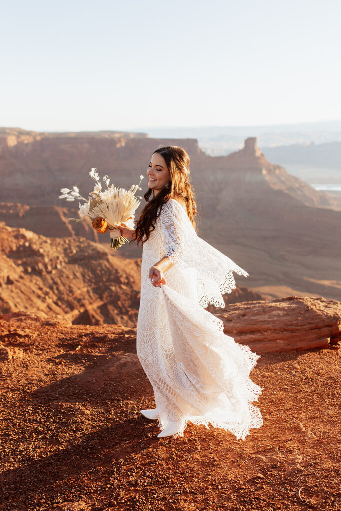 bride walks holding boho wedding bouquet at Dead Horse Point State Park