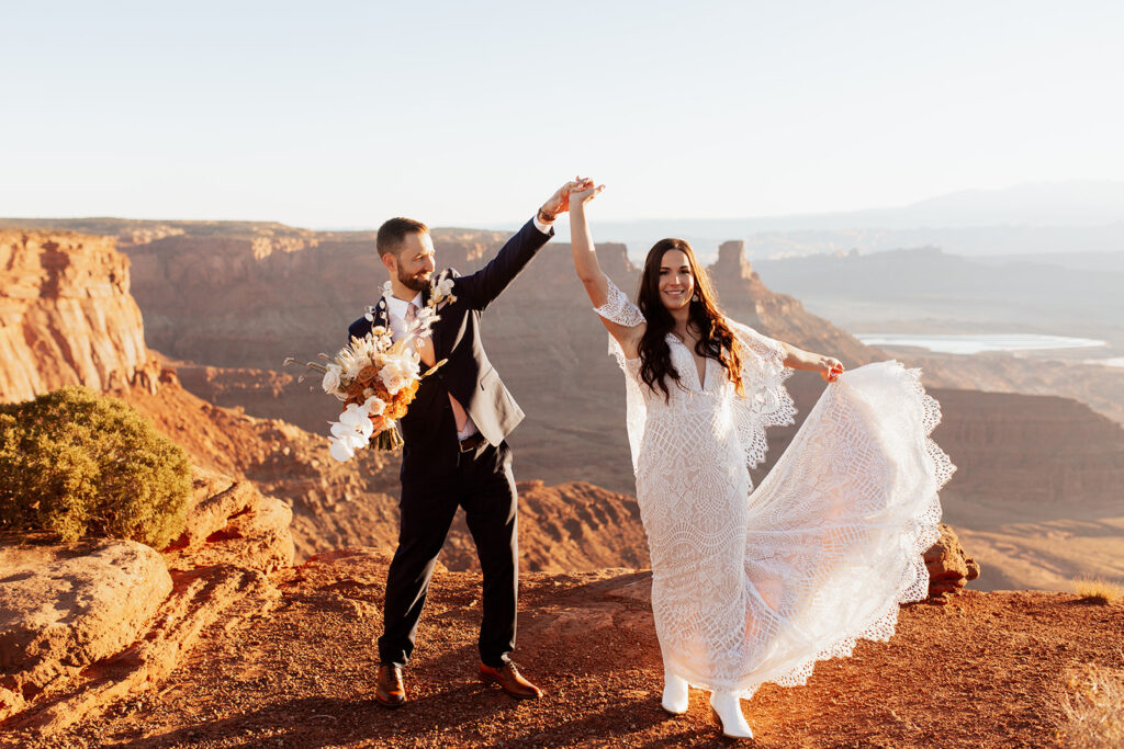 couple holds hands at Dead Horse Point State Park sunrise elopement
