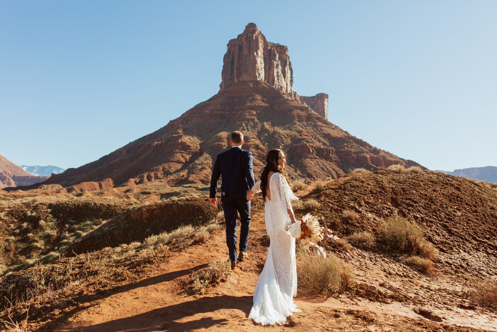 couple walks through Castle Valley at Moab adventure elopement
