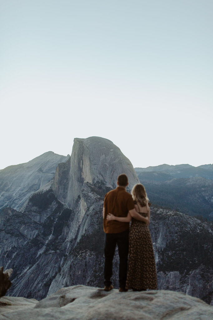 couple embraces at Glacier Point Yosemite overlook