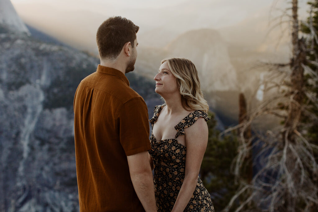 couple holds hands at Glacier Point overlook engagement