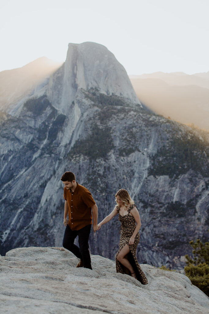 couple walks up Glacier Point overlook at Yosemite sunrise