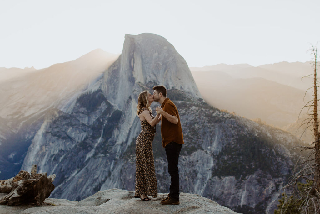 couple kisses at Glacier Point overlook engagement