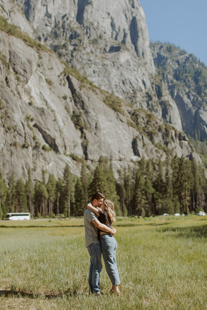 couple kisses in Yosemite Valley field 