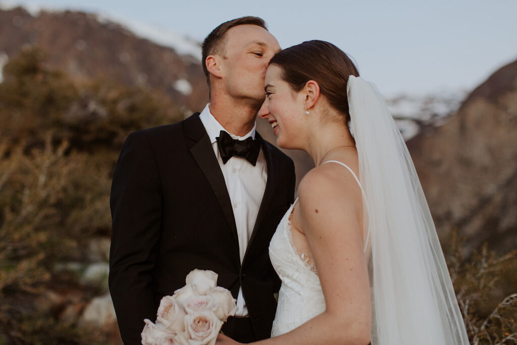 couple kisses at outdoor winter snow-covered elopement