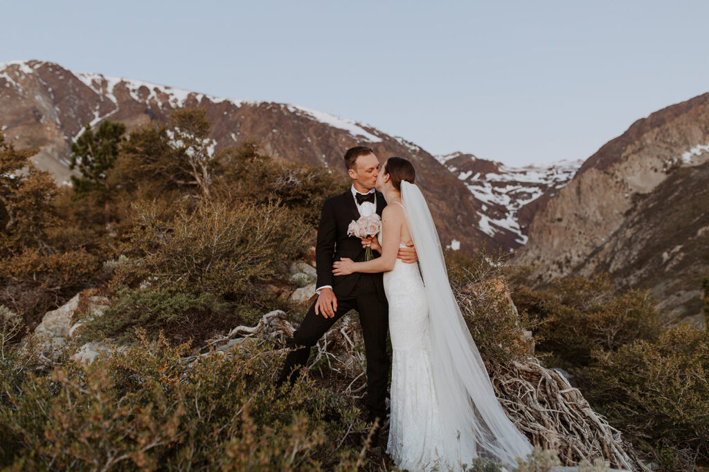 couple kisses at outdoor winter snow-covered elopement