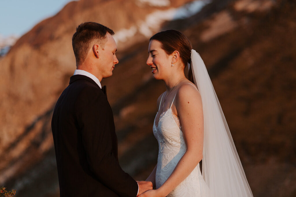 couple holds hands below Sierra Nevada mountains at outdoor elopement