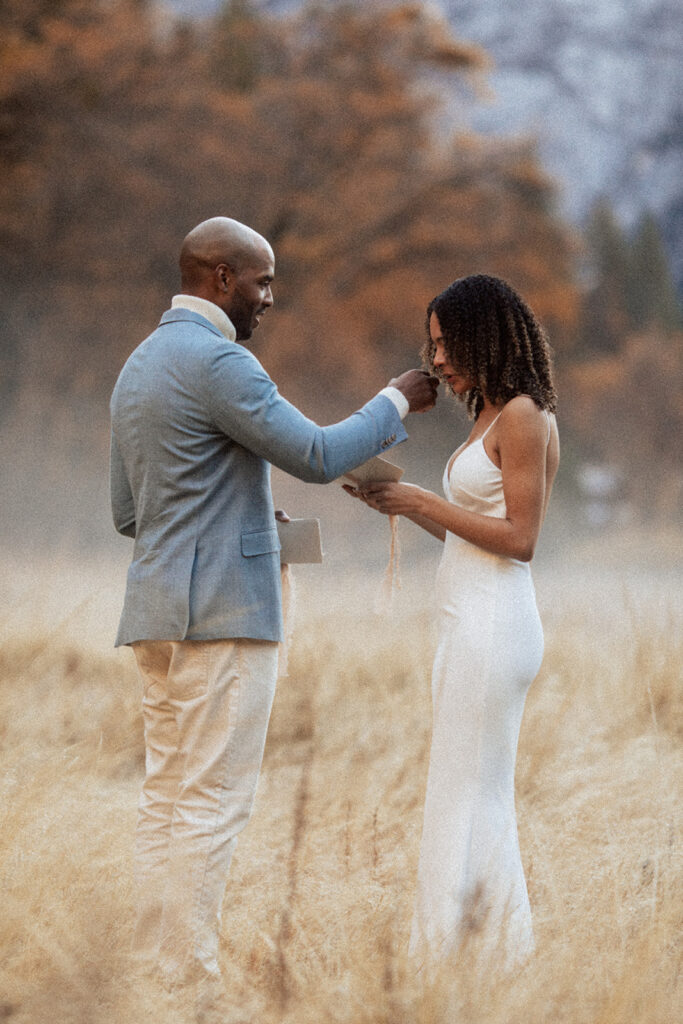 couple exchanges vows in foggy field at sunrise