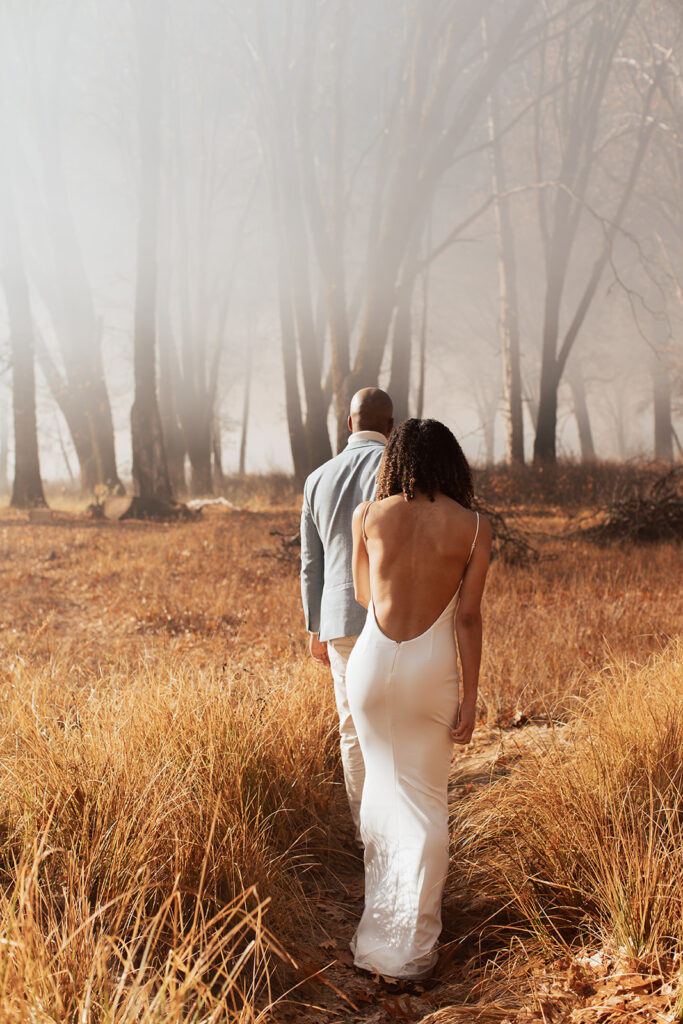 couple walks through foggy woods at Yosemite elopement