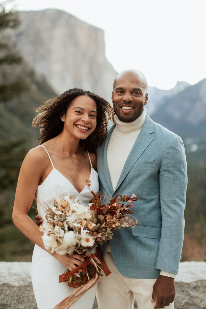 couple embraces smiling in Tunnel View at Yosemite National Park