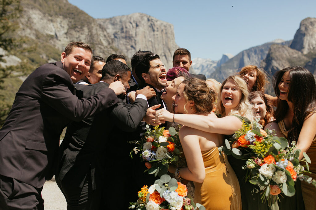 couple gets surrounded by wedding party hugging them