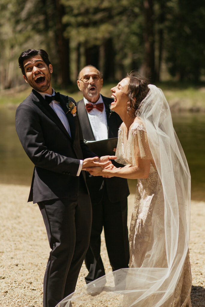 couple laughs during riverside wedding ceremony