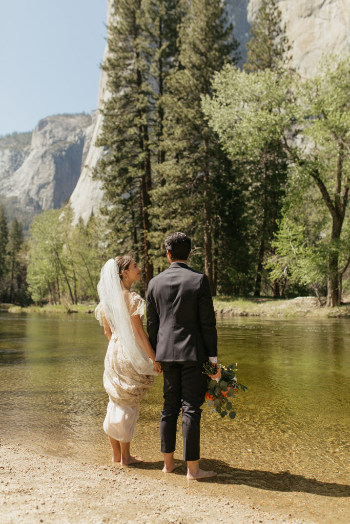 wedding couple stands in Merced River 