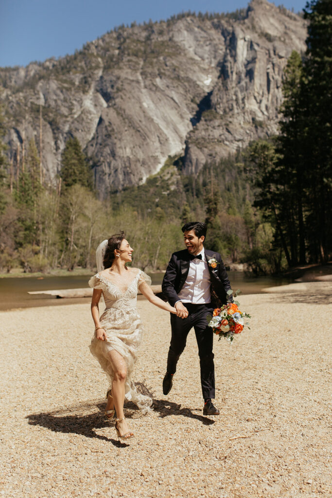 couple runs holding hands at Yosemite Valley elopement