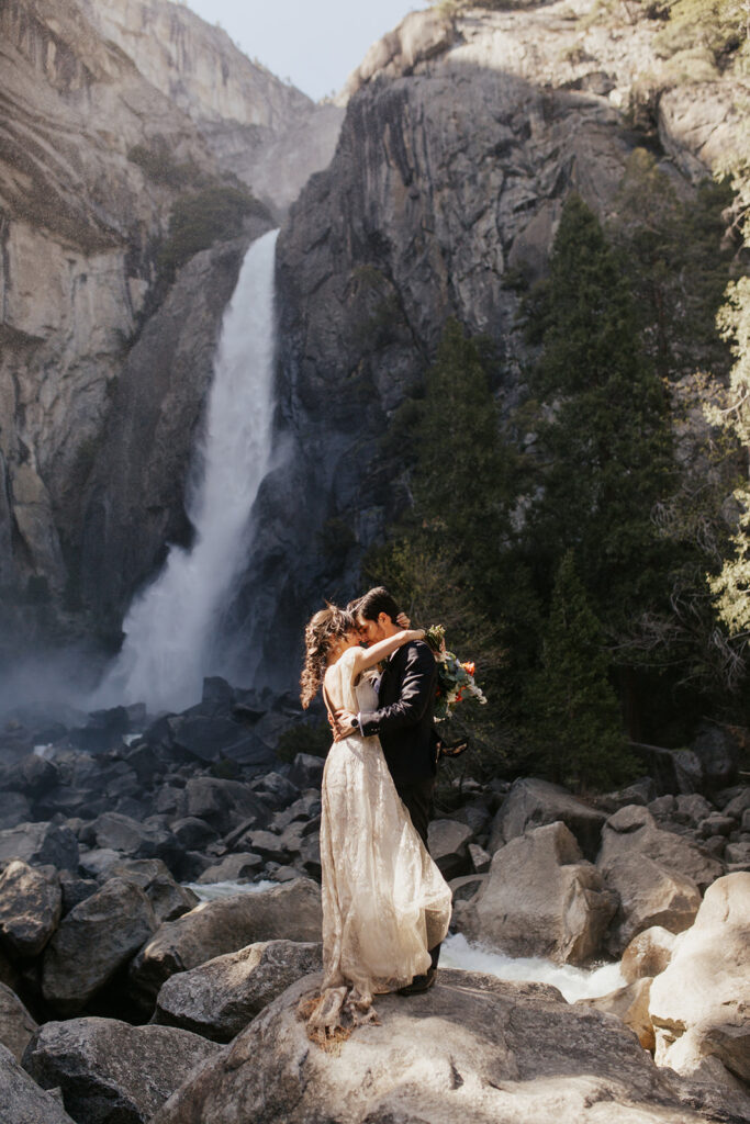 couple embraces beside Yosemite Falls during elopement