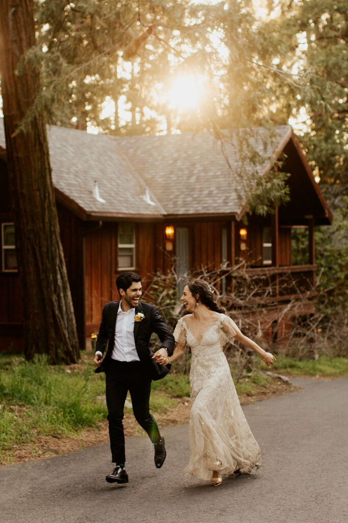 couple runs through woods at sunset wedding