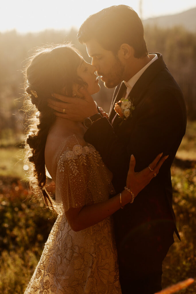 couple kisses during sunset wedding in woods