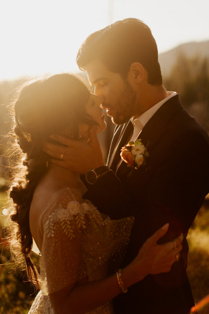 couple kisses during sunset wedding in woods