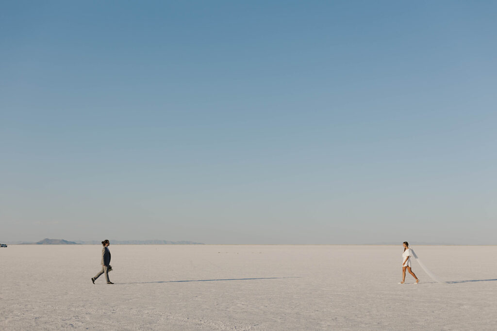 couple walks towards each other at Bonneville Salt Flats sunset elopement