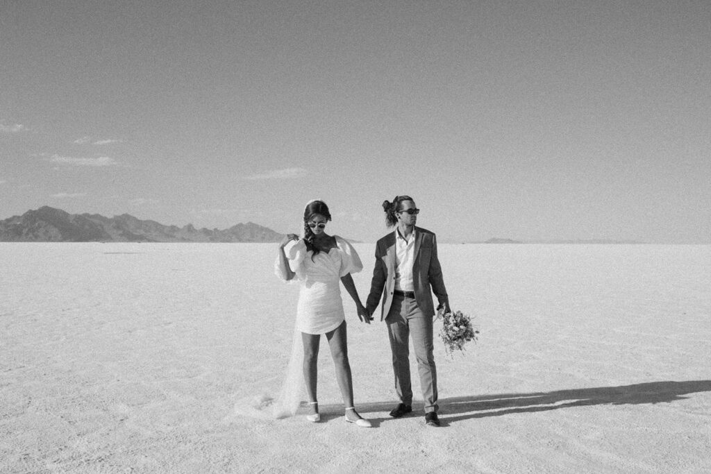 couple holds hands at Bonneville Salt Flats Sunset elopement