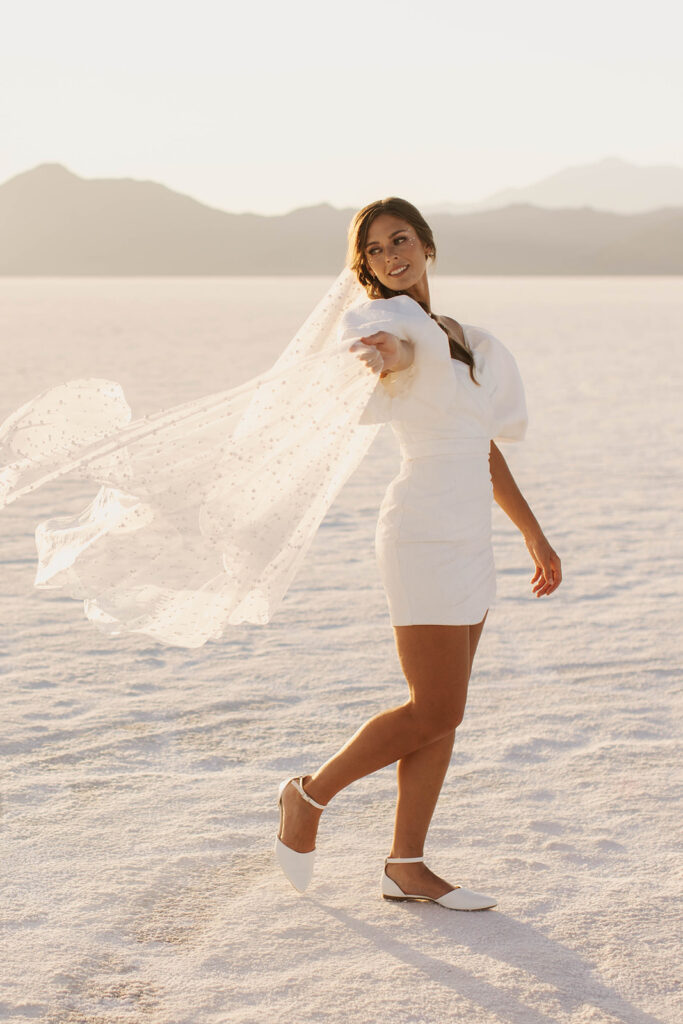 bride twirls pearl-studded veil at Bonneville Salt Flats sunset elopement