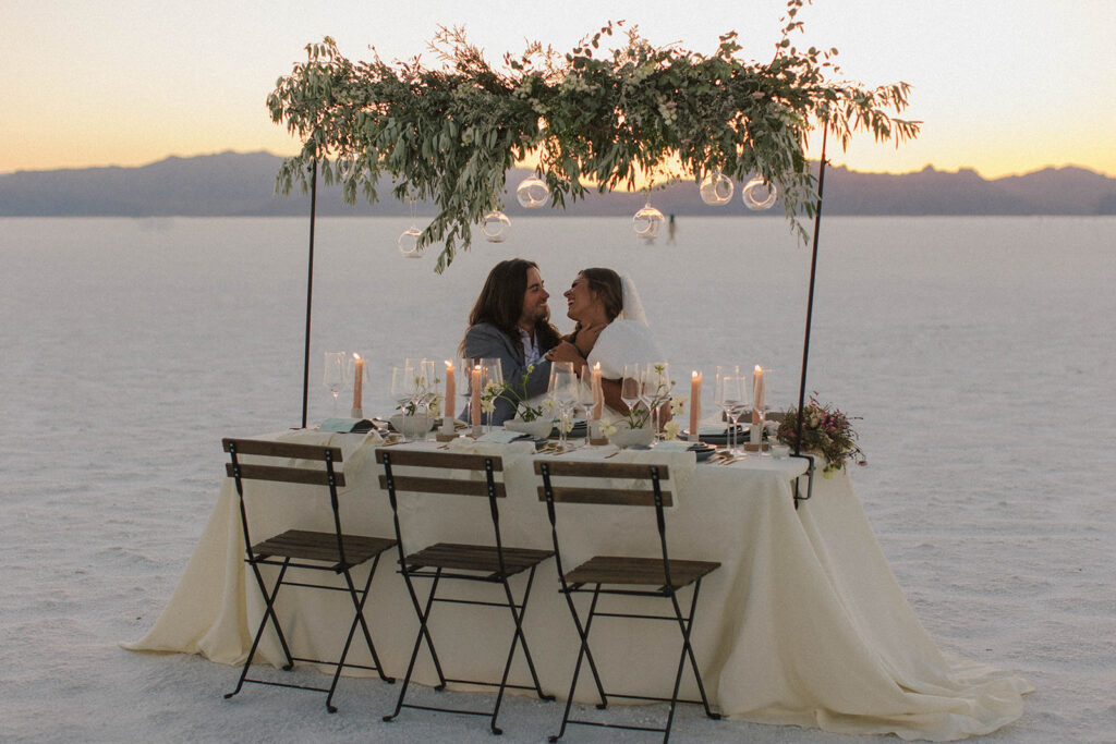 couple sits together at reception table at salts flats wedding